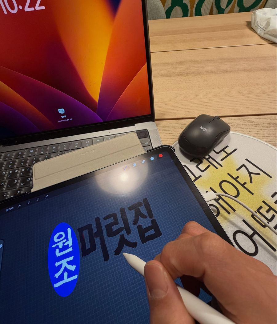 아이패드에 머릿집 로고를 직접 그리는 손